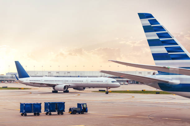 zwei flugzeuge auf asphalt mit fracht am flughafen - airport usa business ohare airport stock-fotos und bilder