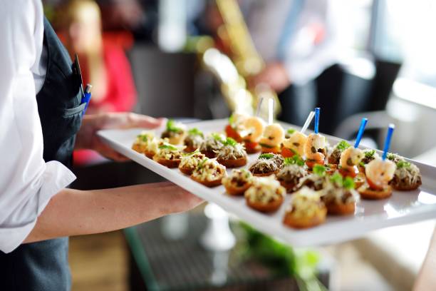 Waiter carrying plates with meat dish Waiter carrying plates with meat dish on some festive event, party or wedding reception tray stock pictures, royalty-free photos & images