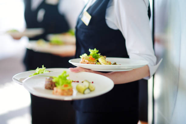 istock Waiter carrying plates with meat dish on some festive event 1054862746
