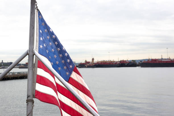 Red Hook, Brooklyn, NY: An American flag flies in the foreground with Red Hook’s industrial waterfront in the background. Shot from the water.