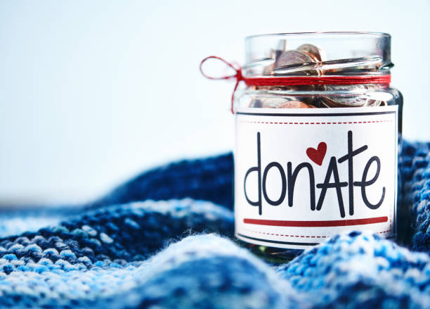 Brightly lit donation money jar filled with coins