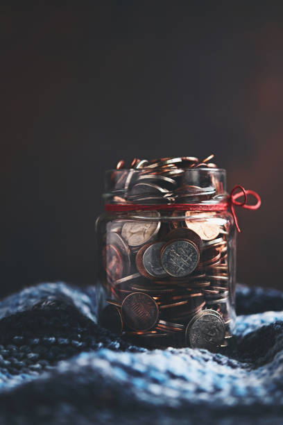 istock Glass money jar filled with coins 1054864146