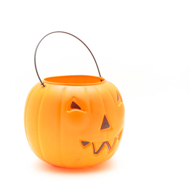 istock Funny face on plastic Halloween pumpkin pail isolated on white 1054868284