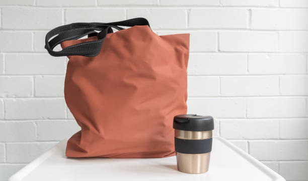 istock Reusable coffee cup and shopping tote bag on white table 1054868470