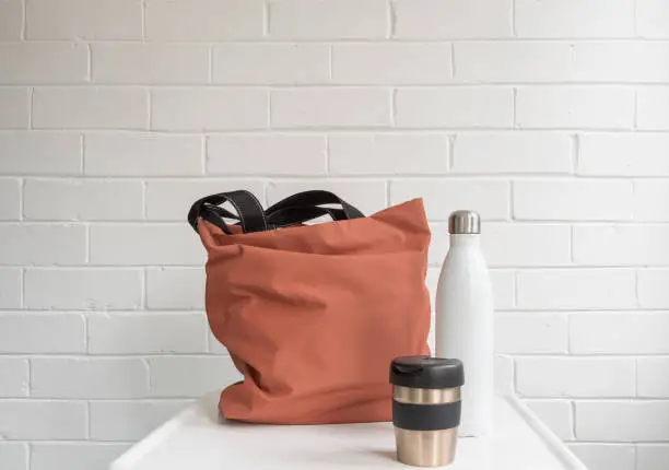 Photo of Reusable coffee cup, insulated drink bottle and shopping tote bag