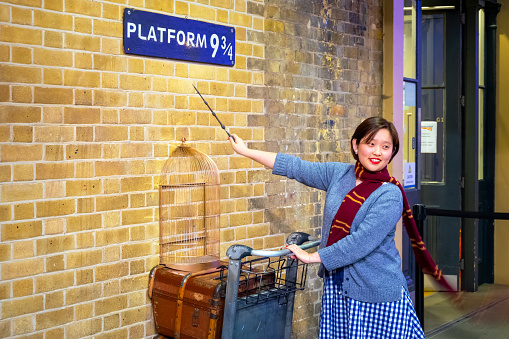London, UK - May 12 2018: Unidentified people poses at the platform 9 3/4 that taken from Harry Potter movie in King's Cross station