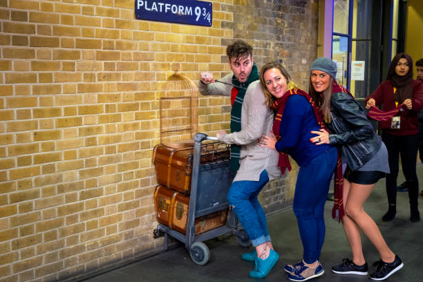 London, UK - May 12 2018: Unidentified people poses at the platform 9 3/4 that taken from Harry Potter movie in King's Cross station