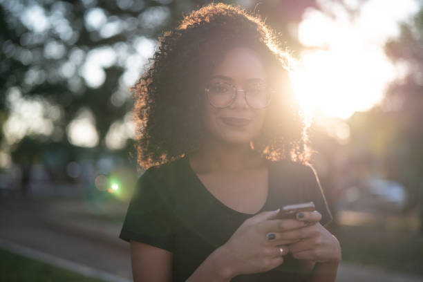 istock Beautiful Curly Hair Woman Using Mobile 1054874596