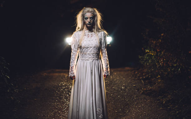 istock Witch in white dress on road 1054874826