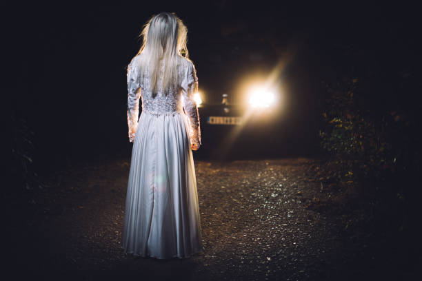 istock Witch standing in front of a car 1054874858