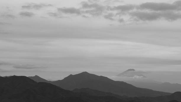 istock Mountains, with Mt. Fuji hiding behind clouds just behind in black and white 1054877794