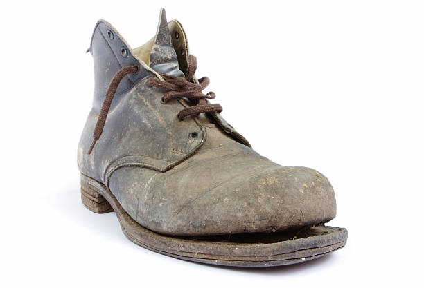 istock An dirty, old, lace up boot with the sole falling off 105487989
