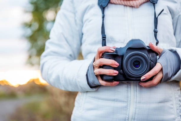 istock Beautiful Young Woman Taking picture with Digital Camera at Sunset 1054889220