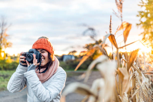istock Beautiful Young Woman Taking picture with Digital Camera at Sunset 1054889302