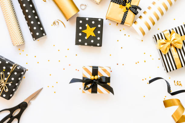 istock Top view of gift boxes and wrapping materials in various black, white and golden designs. A concept of Christmas, New Year, birthday celebration event. 1054894426
