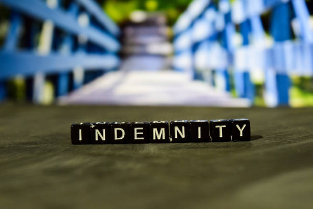 Indemnity on wooden blocks. Business and finance concept. Cross processed image with bokeh background