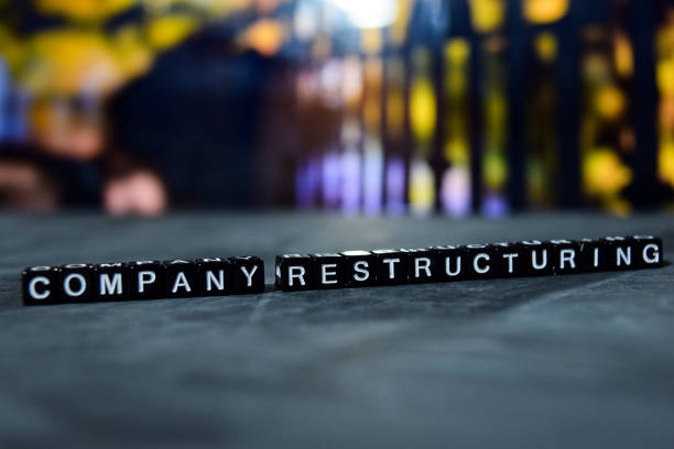 Company restructuring on wooden blocks. Business and finance concept. Cross processed image with bokeh background