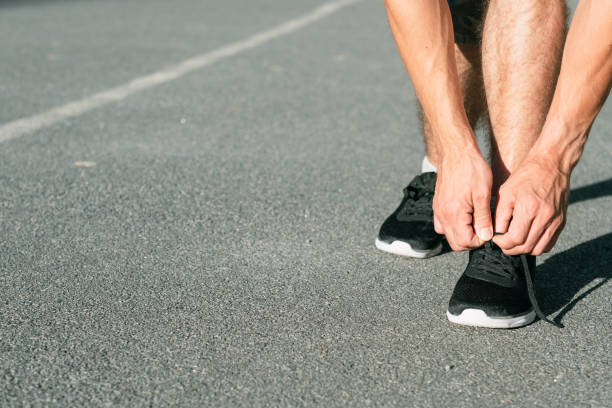 istock runner tying shoelaces track field athletics sport 1054898894