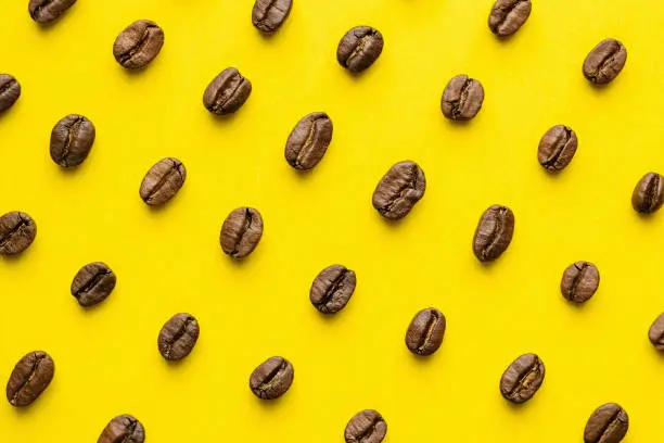 Photo of Coffee beans pattern on yellow background