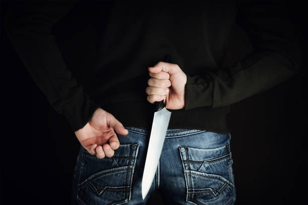 riminal with large sharp knife behind his back criminal with large sharp knife behind his back ready for robbery or to commit a homicide knife crime photos stock pictures, royalty-free photos & images