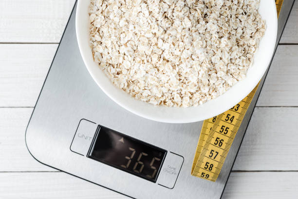 istock Oatmeal in a white plate on the kitchen scale 1054899204