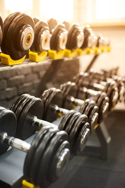 istock dumbbells row in a gym. sport sunny background 1054901272
