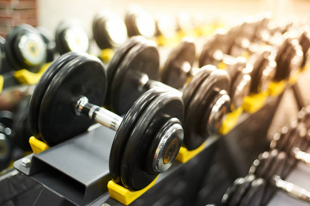 istock dumbbells row in a gym. sport sunny background 1054901316