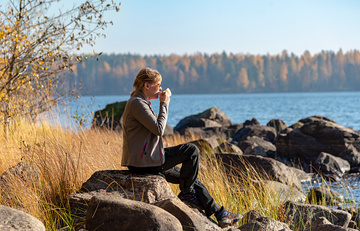 Woman drinking coffee in outdoor at lake