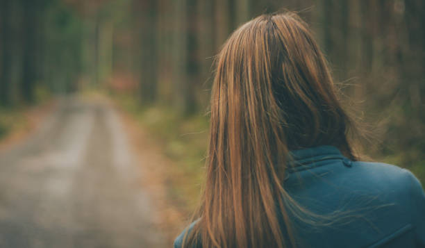 istock Back view of a woman in a forest 1054901650