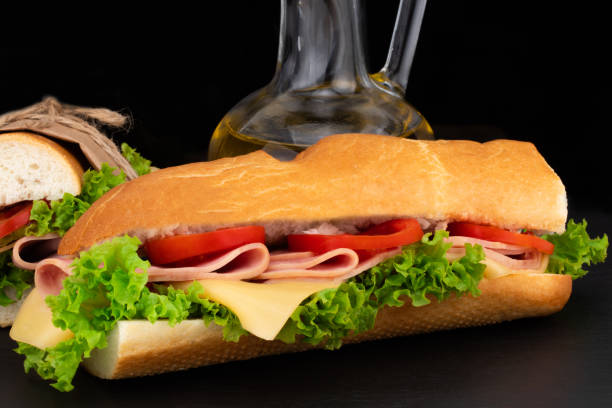 istock sandwich with  with ham, cheese, tomatoes, lettuce on  over stone. Top view with copy space 1054901932