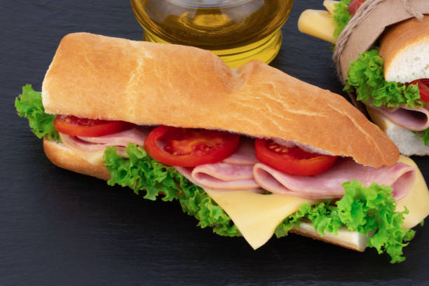 istock sandwich with  with ham, cheese, tomatoes, lettuce on  over stone. Top view with copy space 1054901942