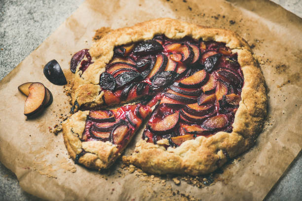 istock Round plum galetta cake on baking paper over concrete background 1054905586