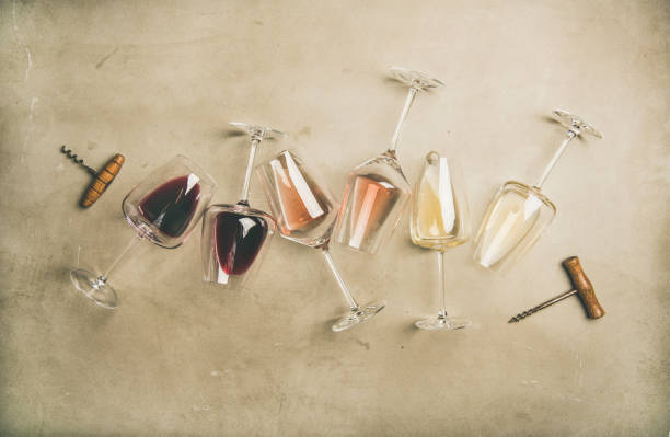 Red, rose and white wine in glasses and corkscrews Flat-lay of red, rose and white wine in glasses and corkscrews over grey concrete background, top view, horizontal composition. Wine bar, winery, wine degustation concept winemaking photos stock pictures, royalty-free photos & images