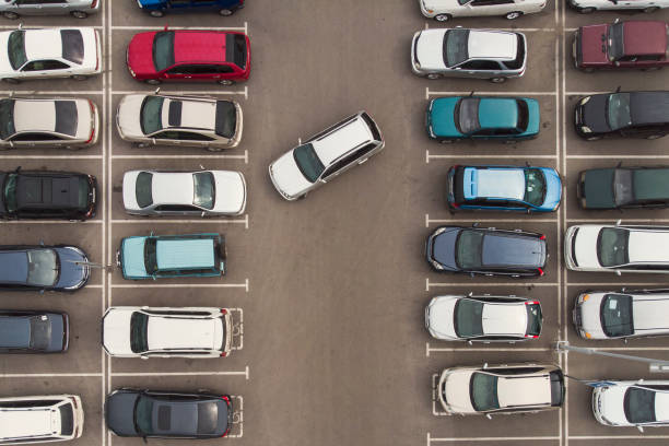 régularité dans un parking auto. une vue vers les rangs soigneusement garées des voitures. navigation automobile dans le parc automobile. vous cherchez des locaux vacants pour le stationnement. le parc est bloqué avec des voitures. problèmes de statio - mannered photos et images de collection