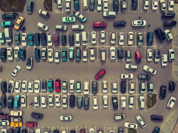 view from above to the process of car parking. heavy traffic in parking lot. searching for spaces in the car park. leaving car in the stand. cruising in a busy business center. setup difficulties. - mannered imagens e fotografias de stock