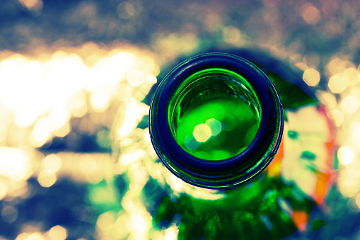 green bottle with alcohol on light background