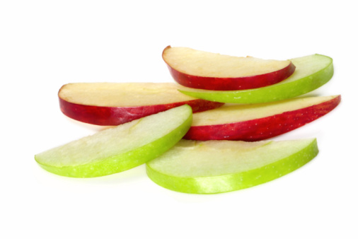 Apple slices, on white background.  Thin wedges of green granny smith and red delicious apples, makes a healthy snack.