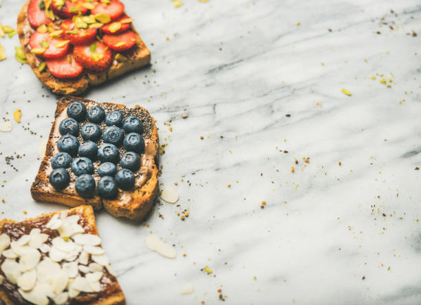 istock Vegan whole grain toasts with fruit, seeds, nuts, marble background 1054912928