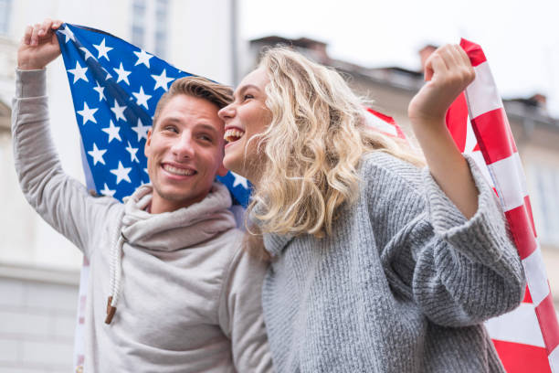 istock Happy young couple holding American flag 1054913492