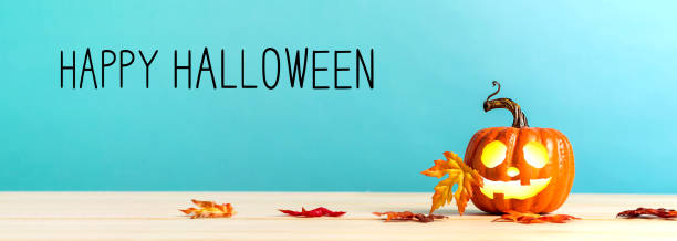 istock Happy Halloween message with pumpkin on a table 1054914986