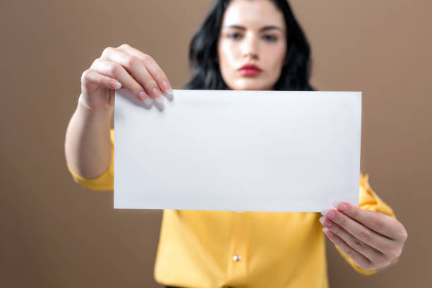 istock Young woman holding up a blank sign 1054916036