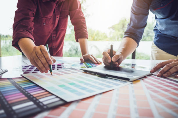 istock Two colleagues creative graphic designer working on color selection and drawing on graphics tablet at workplace 1054918120