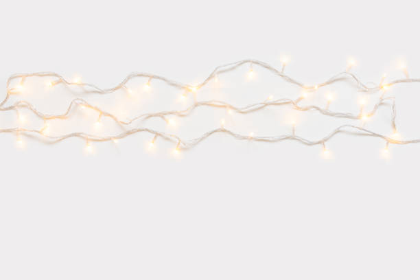 istock Christmas lights in warm yellow white on string over light background with copy space for text, logo decoration on Xmas eve celebration, special holidays, new year event 1054919702