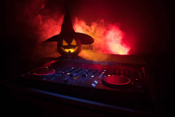 zucca di halloween su un tavolo dj con cuffie su sfondo scuro con spazio di copia. buone decorazioni del festival di halloween e concetto musicale - human face foto e immagini stock