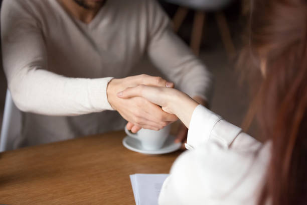 istock Close up of husband handshake relator signing contract in cafe 1054920522