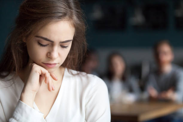 istock Sad young girl feeling lonely sitting alone in cafe 1054920546