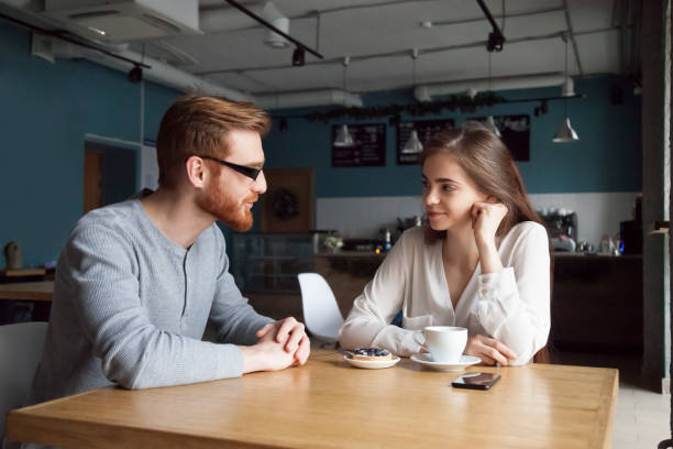 istock Young guy get acquainted with pretty girl in cafe 1054920564