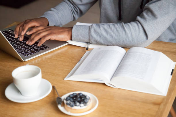 istock Close up of guy using laptop sitting in cafe 1054920626