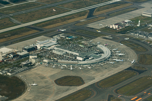 Wing of a landing Boeing 777-300 with a view to the aircraft control tower in Copenhagen Airport