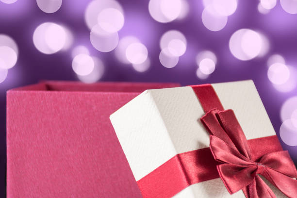 istock Red opened gift box with bow and purple background with bokeh 1054922194